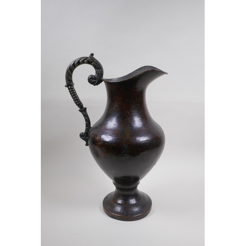 46 - A patinated hammered copper urn with bronze handle, 39cm high