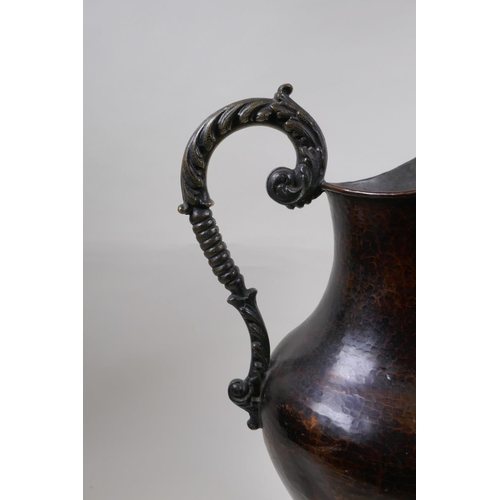 46 - A patinated hammered copper urn with bronze handle, 39cm high