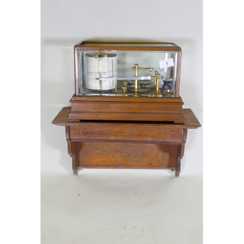 5 - A brass barograph in a glazed oak case with wall bracket fitted with a drawer, glass cracked, drawer... 