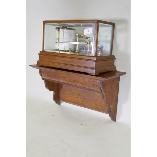 5 - A brass barograph in a glazed oak case with wall bracket fitted with a drawer, glass cracked, drawer... 