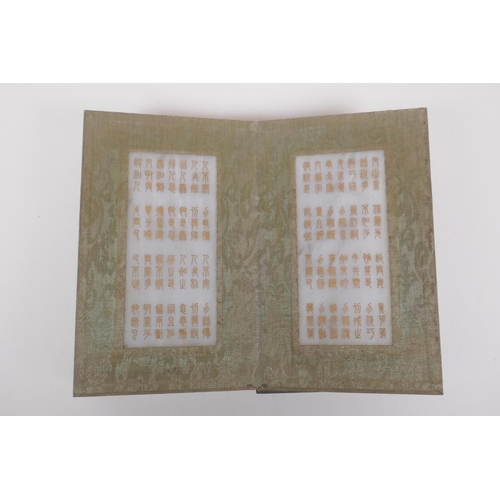 51 - A Chinese wood and silk bound book containing white jade tablets with chased and gilt character insc... 