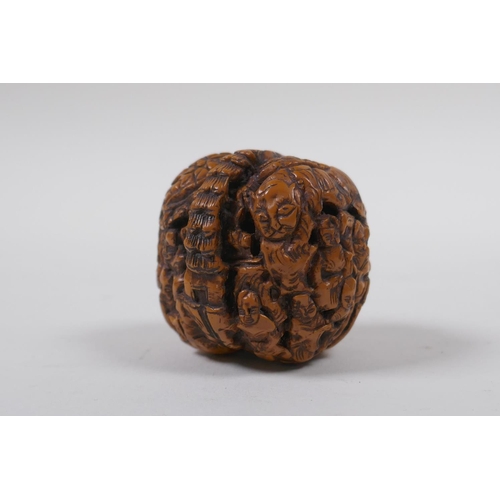 53 - A Chinese carved walnut kernel with figural decoration, 4cm diameter