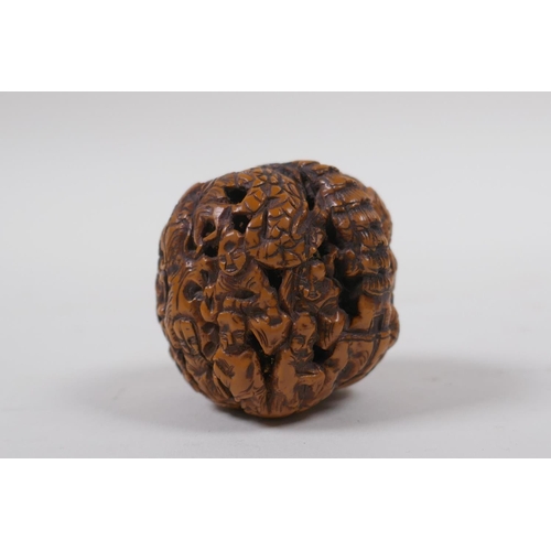 53 - A Chinese carved walnut kernel with figural decoration, 4cm diameter