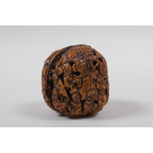 53 - A Chinese carved walnut kernel with figural decoration, 4cm diameter