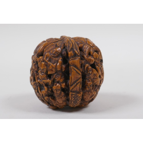 53 - A Chinese carved walnut kernel with figural decoration, 4cm diameter