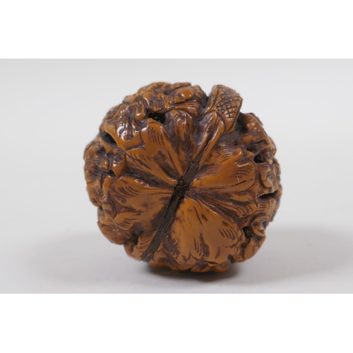 53 - A Chinese carved walnut kernel with figural decoration, 4cm diameter