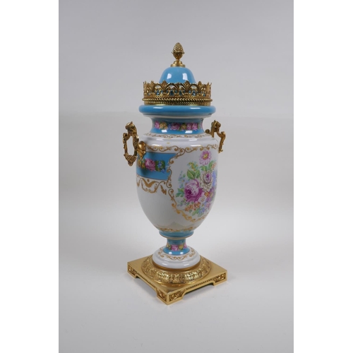 54 - A Sevres style continental porcelain urn with brass mounts, handles and base, with floral bouquet an... 