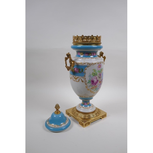 54 - A Sevres style continental porcelain urn with brass mounts, handles and base, with floral bouquet an... 