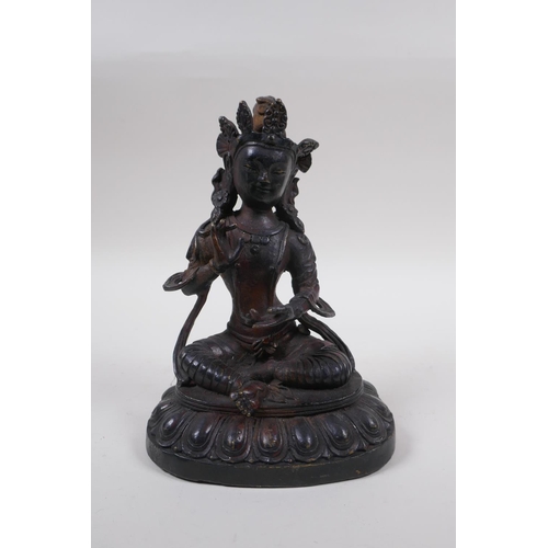 63 - A Sino Tibetan bronze of Buddha, with remnants of gilt and copper patina, 20cm high