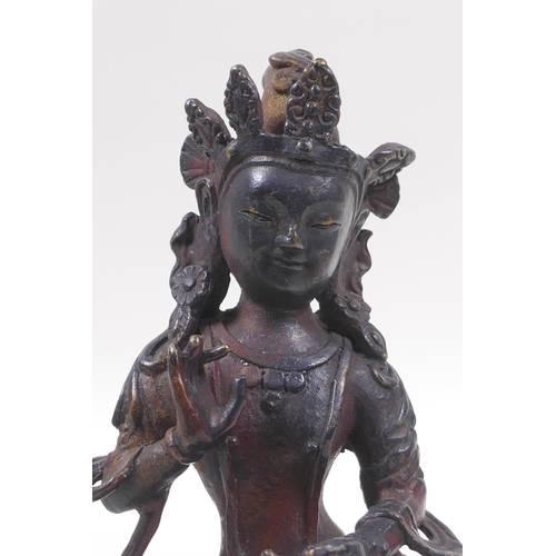 63 - A Sino Tibetan bronze of Buddha, with remnants of gilt and copper patina, 20cm high