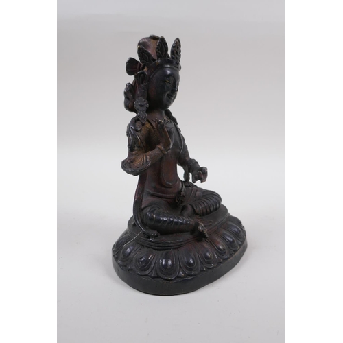 63 - A Sino Tibetan bronze of Buddha, with remnants of gilt and copper patina, 20cm high