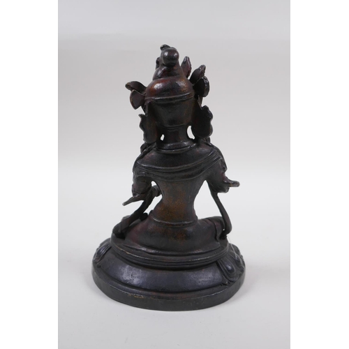 63 - A Sino Tibetan bronze of Buddha, with remnants of gilt and copper patina, 20cm high