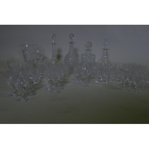 71 - Four cut glass decanters, a jug and various drinking glasses