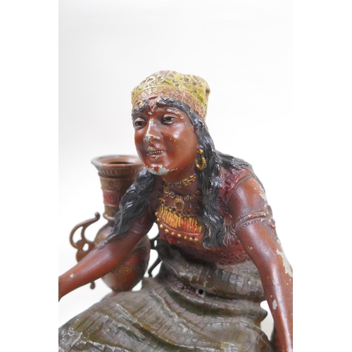 76 - A painted spelter figure of a seated Moorish girl, 22cm wide, 18cm high 