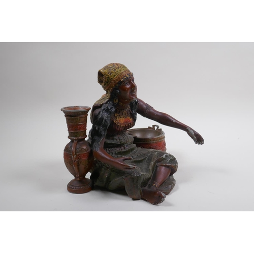 76 - A painted spelter figure of a seated Moorish girl, 22cm wide, 18cm high 