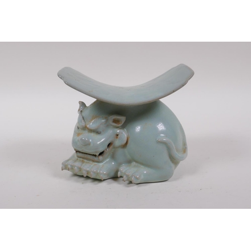 80 - A Chinese ru ware style porcelain pillow, the base in the form of a temple lion, 11cm high