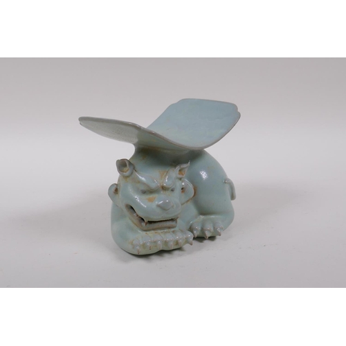 80 - A Chinese ru ware style porcelain pillow, the base in the form of a temple lion, 11cm high