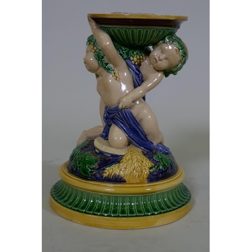 81 - A Victorian majolica centre piece stand in the form of two putti, in the style of Minton, 23cm high,... 