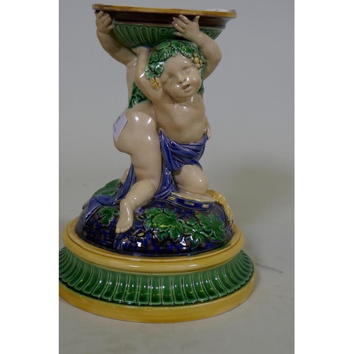 81 - A Victorian majolica centre piece stand in the form of two putti, in the style of Minton, 23cm high,... 