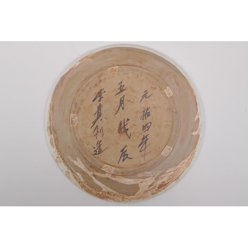 88 - A Chinese Cizhou kiln charger decorated with waterfowl upon a lotus flower pond, character inscripti... 