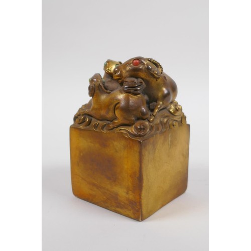 38 - A Chinese filled bronze seal, the mount moulded in the form of three goats with stone set eyes, 6 x ... 