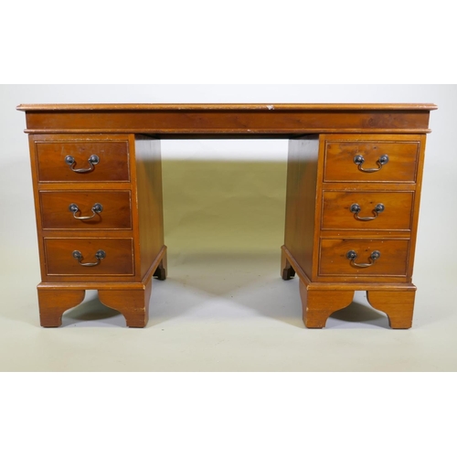 1107 - A yew wood five drawer pedestal desk with leather inset top, raised on bracket supports, 122 x 61 x ... 