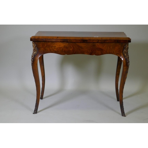 1002 - A C19th figured walnut serpentine front card table, with brass mounts, 92 x 46 x 75cm