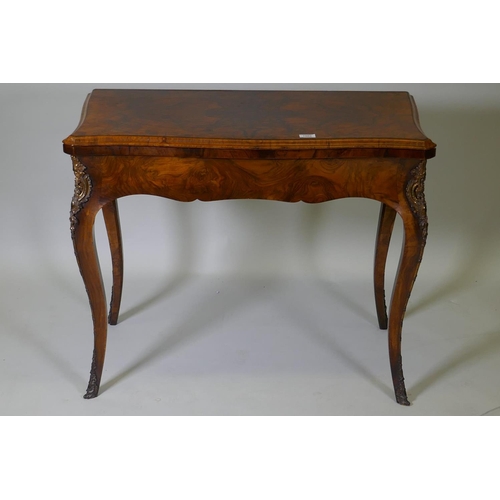 1002 - A C19th figured walnut serpentine front card table, with brass mounts, 92 x 46 x 75cm