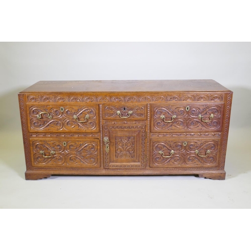 1007 - A carved oak sideboard/buffet with five drawers and a single door, with brass swan neck handles, C18... 