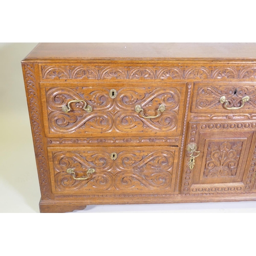 1007 - A carved oak sideboard/buffet with five drawers and a single door, with brass swan neck handles, C18... 