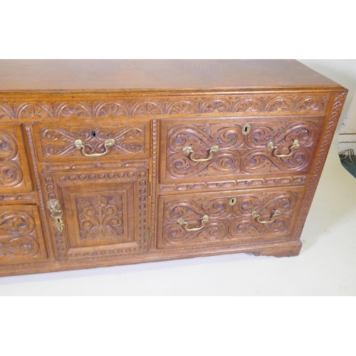 1007 - A carved oak sideboard/buffet with five drawers and a single door, with brass swan neck handles, C18... 