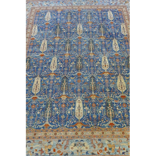 1010 - An Afghan hand woven and knotted Choeb Rang carpet, geometric designs in a muted palette on a blue f... 