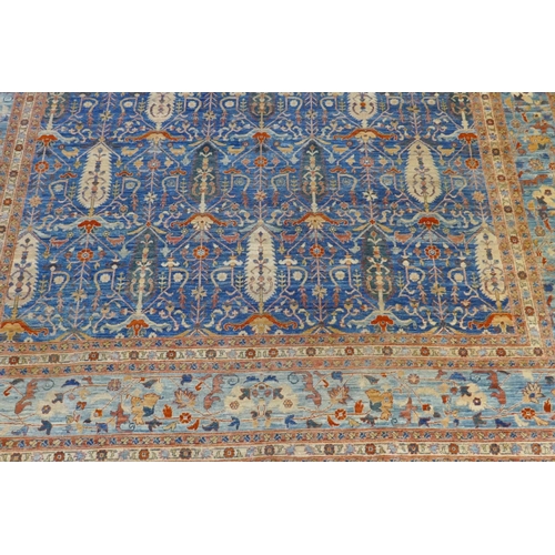 1010 - An Afghan hand woven and knotted Choeb Rang carpet, geometric designs in a muted palette on a blue f... 