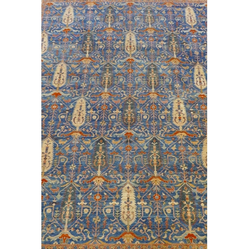 1010 - An Afghan hand woven and knotted Choeb Rang carpet, geometric designs in a muted palette on a blue f... 