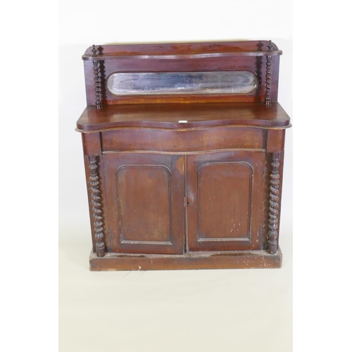 1021 - A Victorian mahogany serpentine front chiffonier, with mirrored back under a shelf, single frieze dr... 