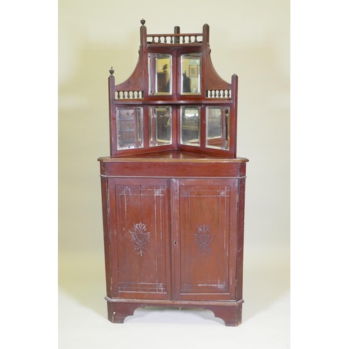 1024 - A Victorian mahogany standing corner cabinet with mirrored back and galleried shelves over two cupbo... 