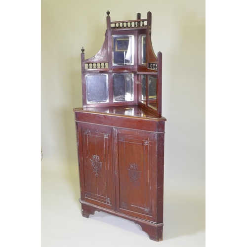 1024 - A Victorian mahogany standing corner cabinet with mirrored back and galleried shelves over two cupbo... 