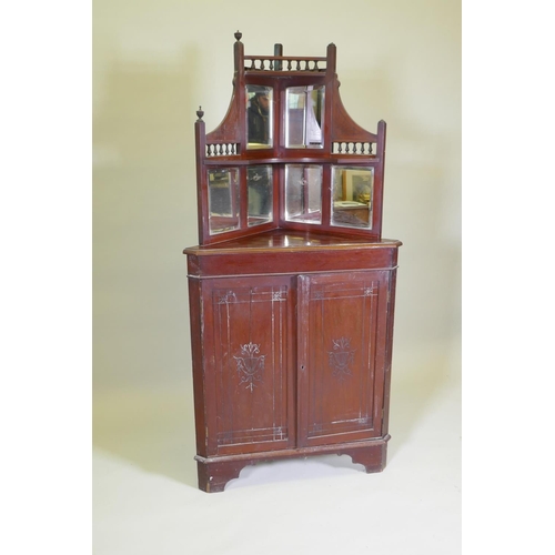 1024 - A Victorian mahogany standing corner cabinet with mirrored back and galleried shelves over two cupbo... 