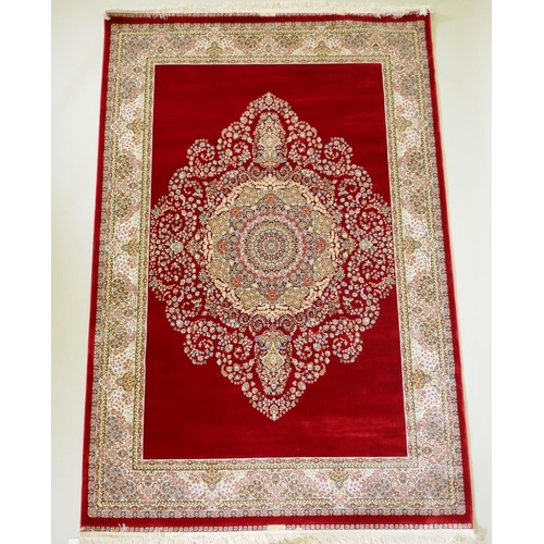 1038 - A rich ruby red ground full pile Qum rug with floral medallion pattern, 158 x 234cm