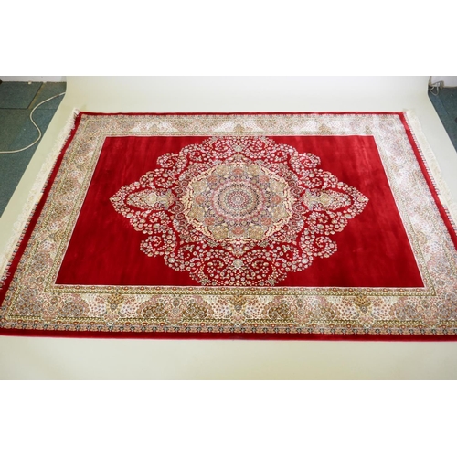 1038 - A rich ruby red ground full pile Qum rug with floral medallion pattern, 158 x 234cm