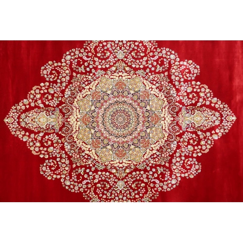 1038 - A rich ruby red ground full pile Qum rug with floral medallion pattern, 158 x 234cm