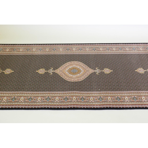 1045 - A deep black ground fine woven full pile Iranian runner with multicolour design, 100 x 408cm