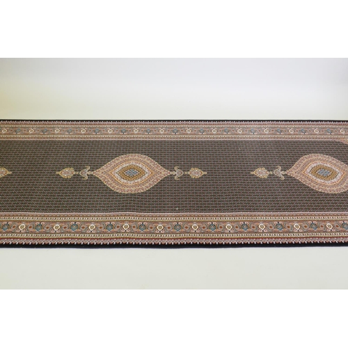 1045 - A deep black ground fine woven full pile Iranian runner with multicolour design, 100 x 408cm