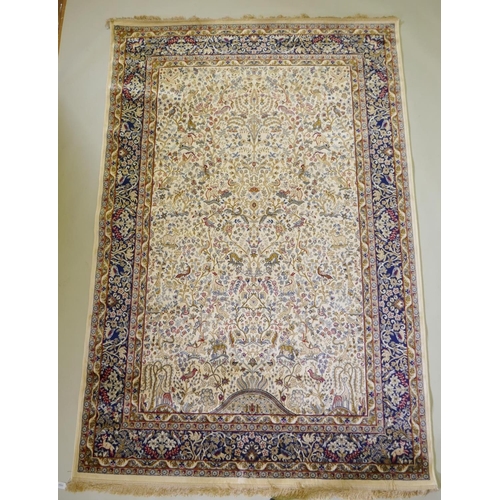 1050 - An ivory ground Kashmir full pile rug with tree of life design with blue borders, 158 x 234cm