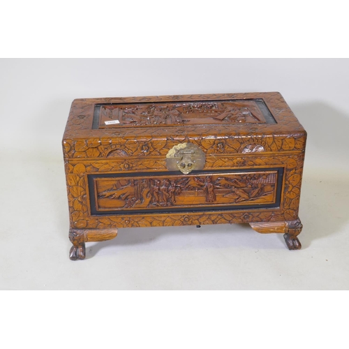 1056 - A small Chinese carved camphor wood coffer, raised on claw feet, 66 x 32 x 38cm