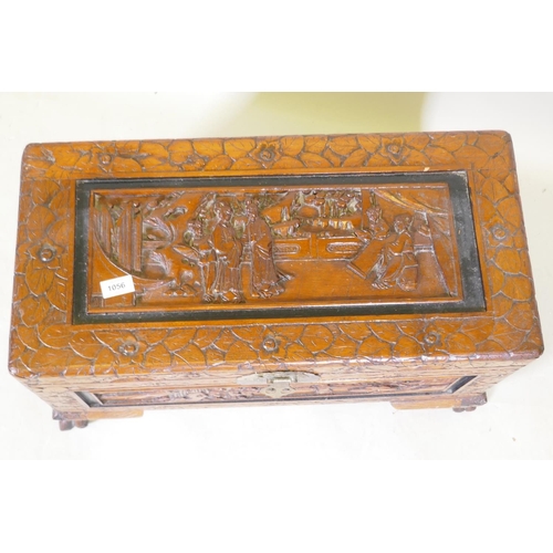 1056 - A small Chinese carved camphor wood coffer, raised on claw feet, 66 x 32 x 38cm