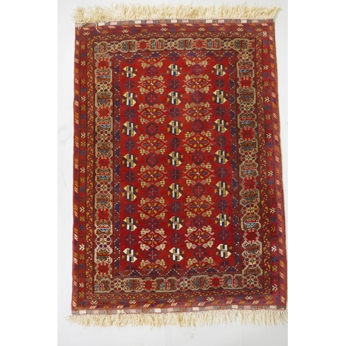 1057 - A Persian red ground wool rug with geometric design, 108 x 148cm