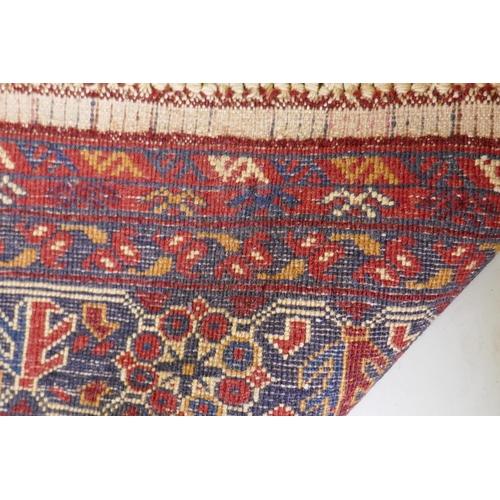 1057 - A Persian red ground wool rug with geometric design, 108 x 148cm