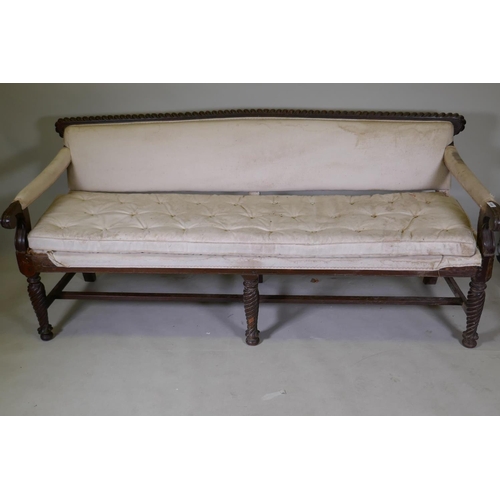 1058 - A C19th Anglo-Indian hardwood settee, with carved gadrooned back and scroll arms, raised on twisted ... 