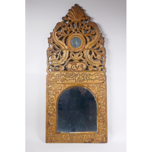 1061 - An Ottoman carved giltwood wall mirror with Islamic script and Hijri date decoration, 37 x 84cm